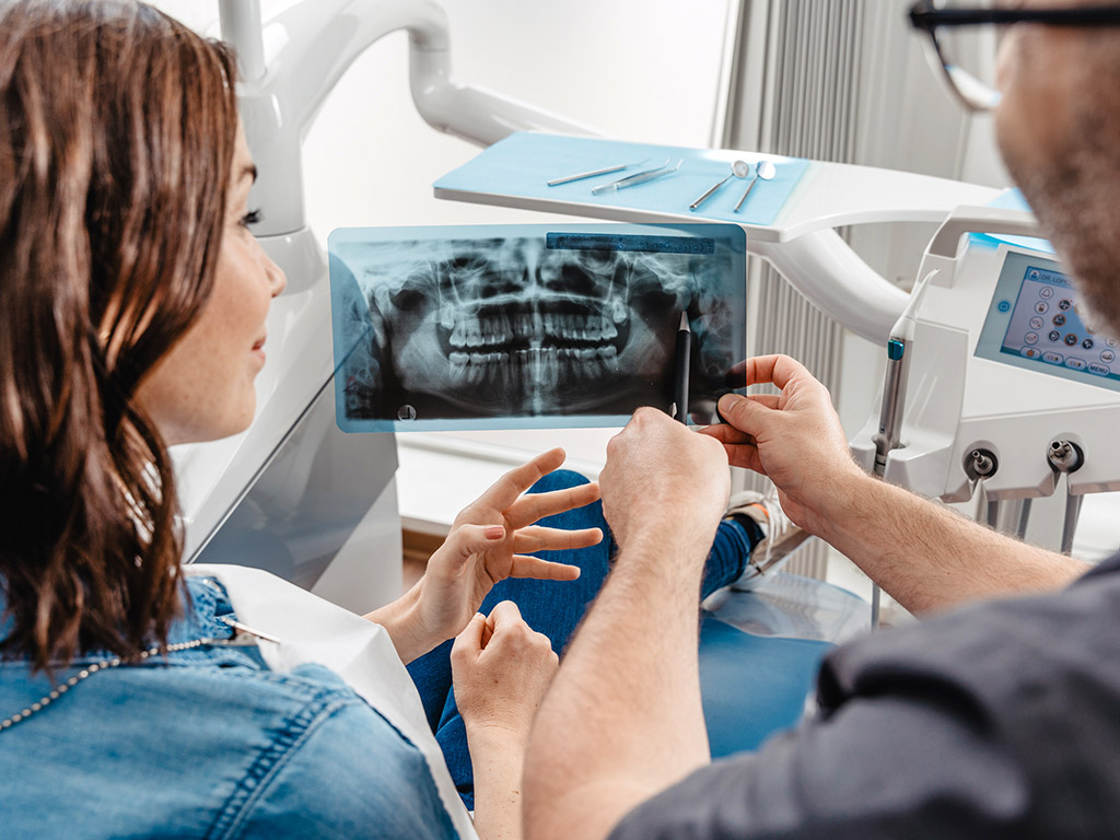 Patientin und Dr. Lopez betrachten Röntgenbild in der Zahnarztpraxis Daaden