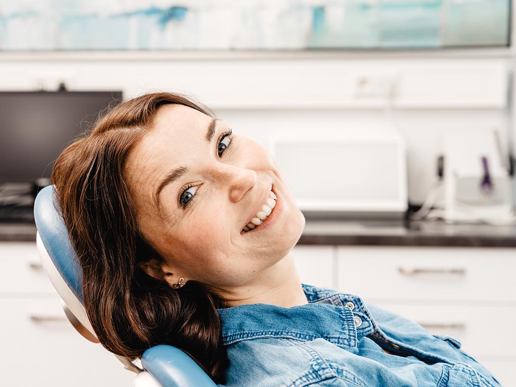 Frau die lacht in der Zahnarztpraxis in Daaden