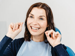 Patientin benutzt Zahnseide bei der professionellen Zahnreinigung im Wäller Mundwerk