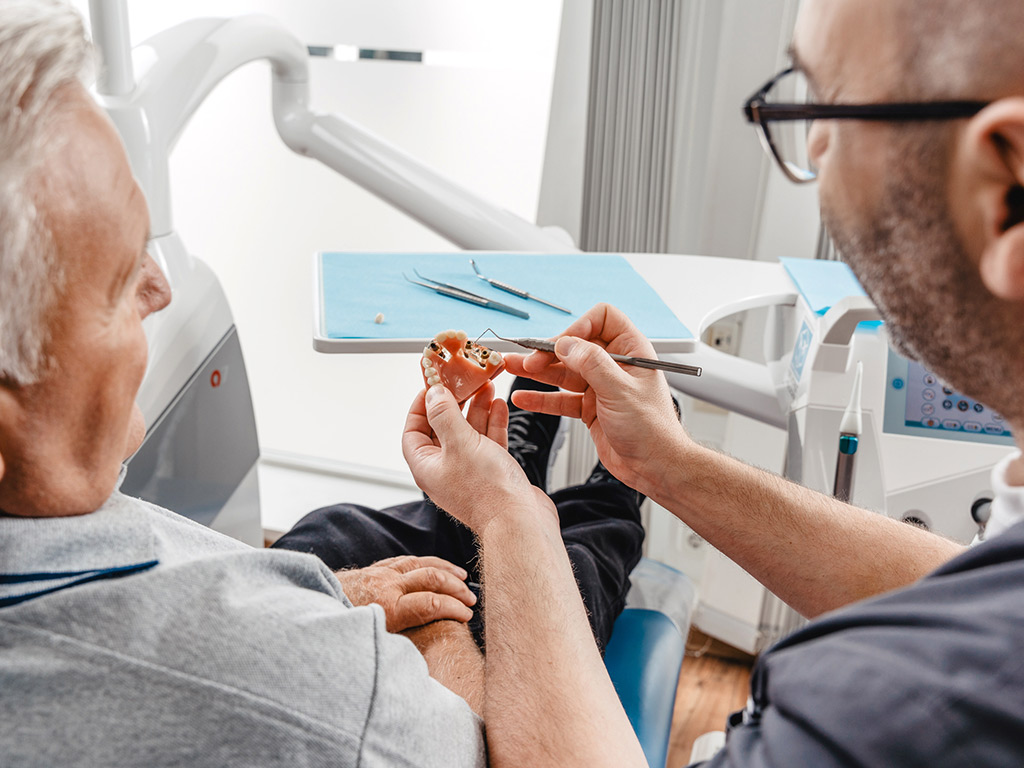 Dr. Lopez erjkärt Patienten eine Zahnprothese